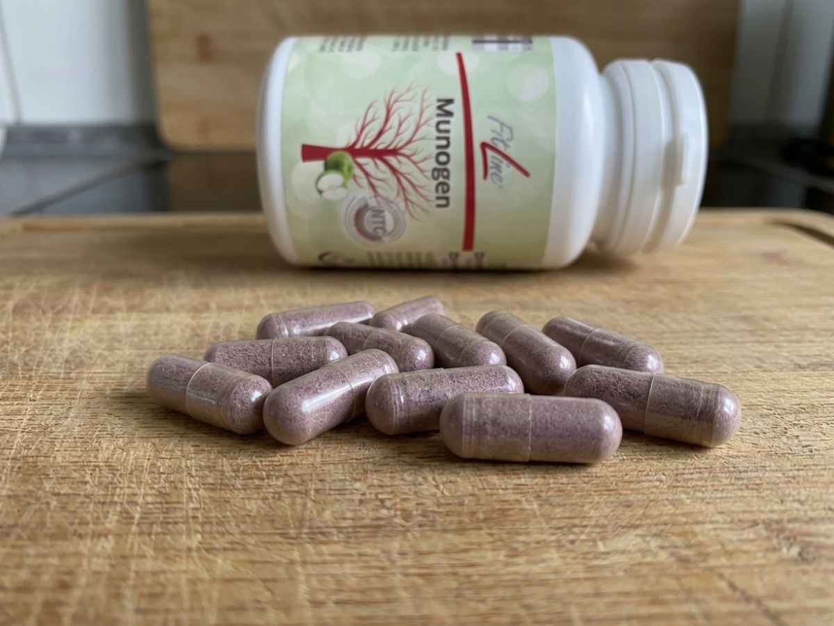 Munogen FitLine: capsule su tagliere con barattolo chiuso coricato, confezione in secondo piano in cucina
